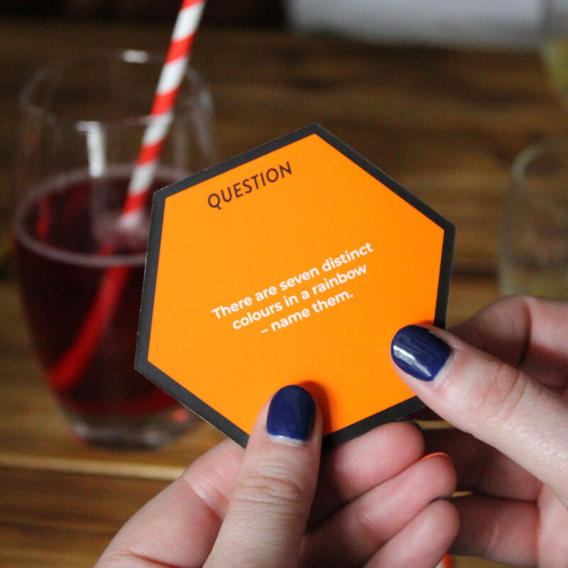 Close up of a hand holding a question card from ginger fox know it all card game