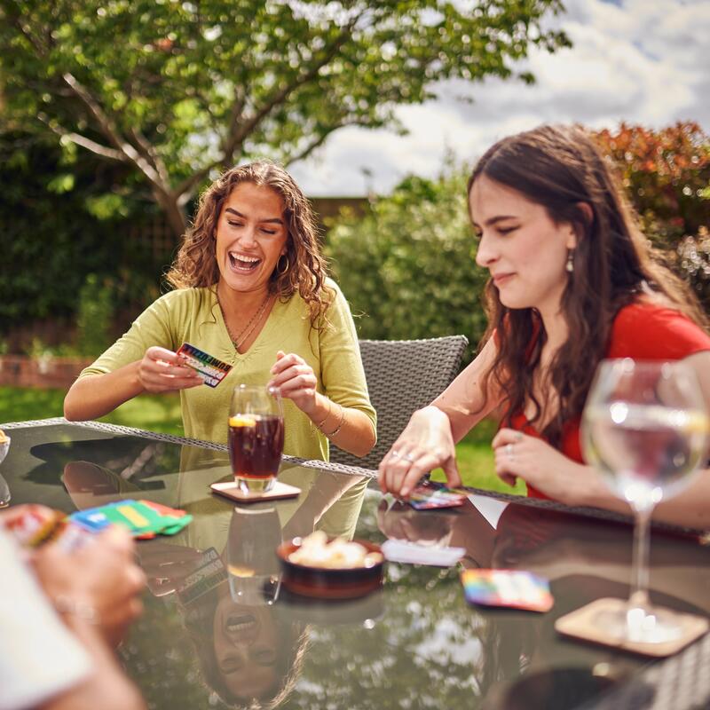 Friends sat outside playing the Bumfuzzle card game